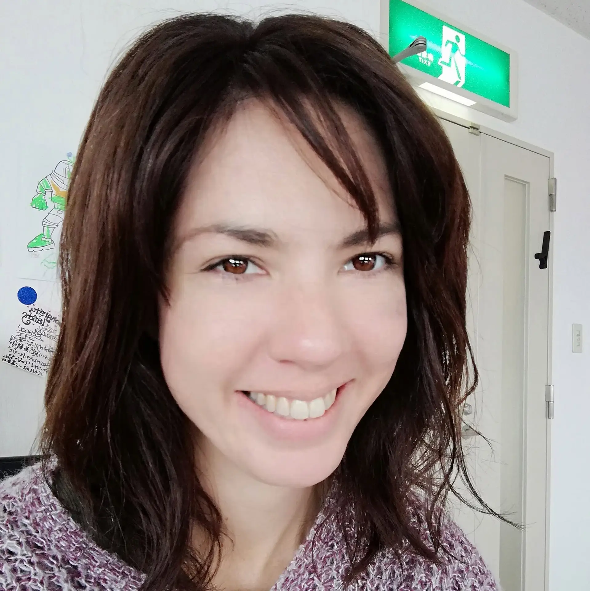 Close-up portrait of a smiling person indoors.