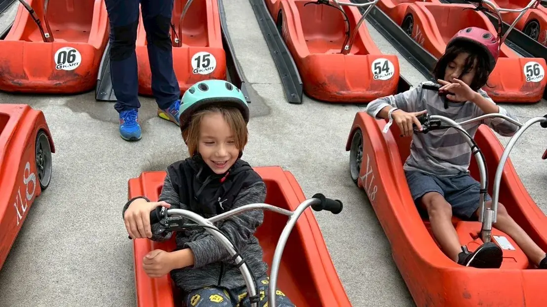 Two com capacete crianças seated em vermelhos pedal go-karts