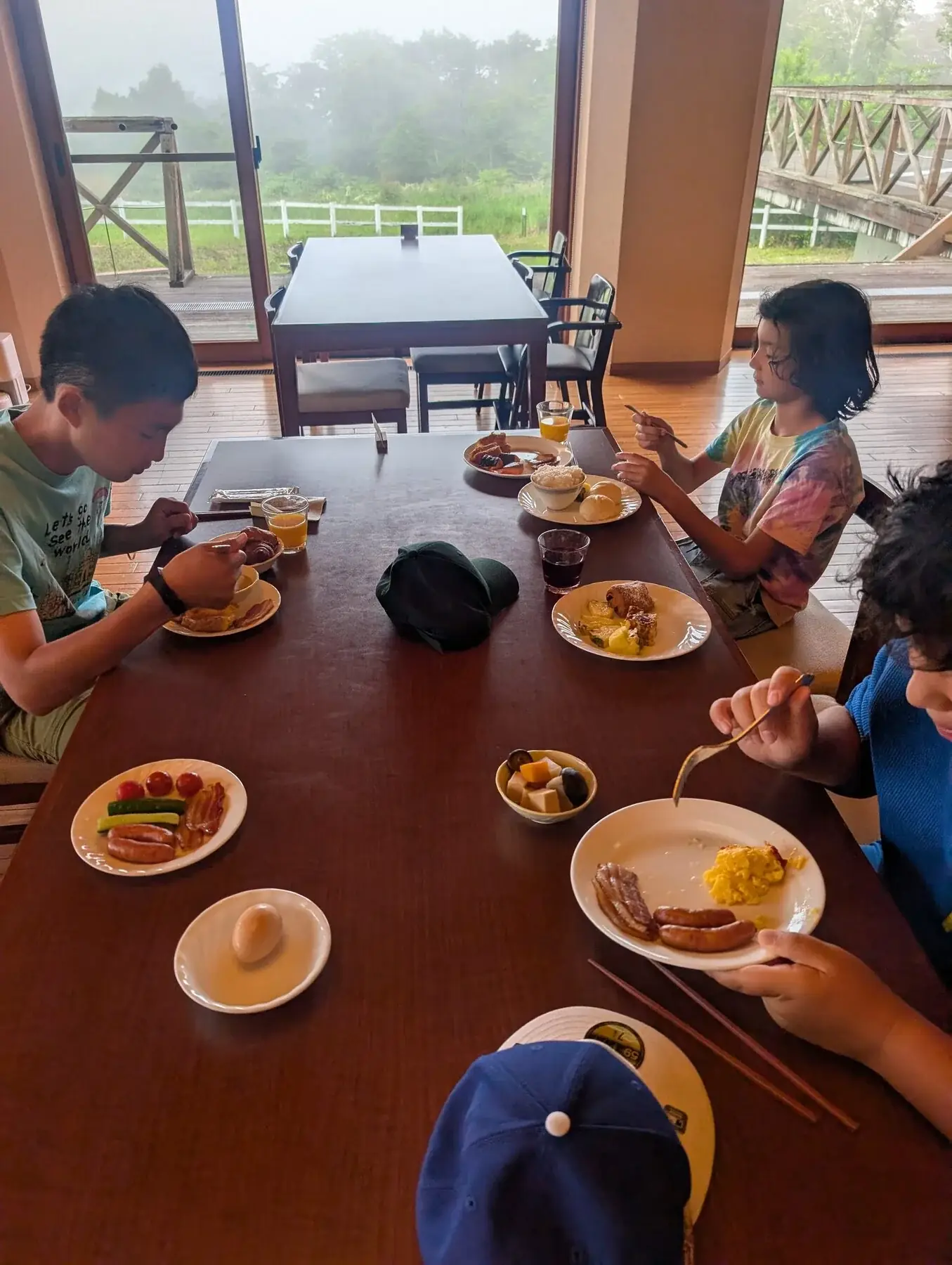 Campers sharing jantar beside um grande window com montanha vistas