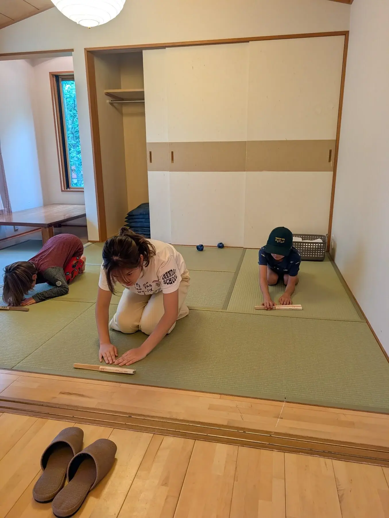 Campers ajoelhados em tatame durante um Nihon Buyo cultural atividade